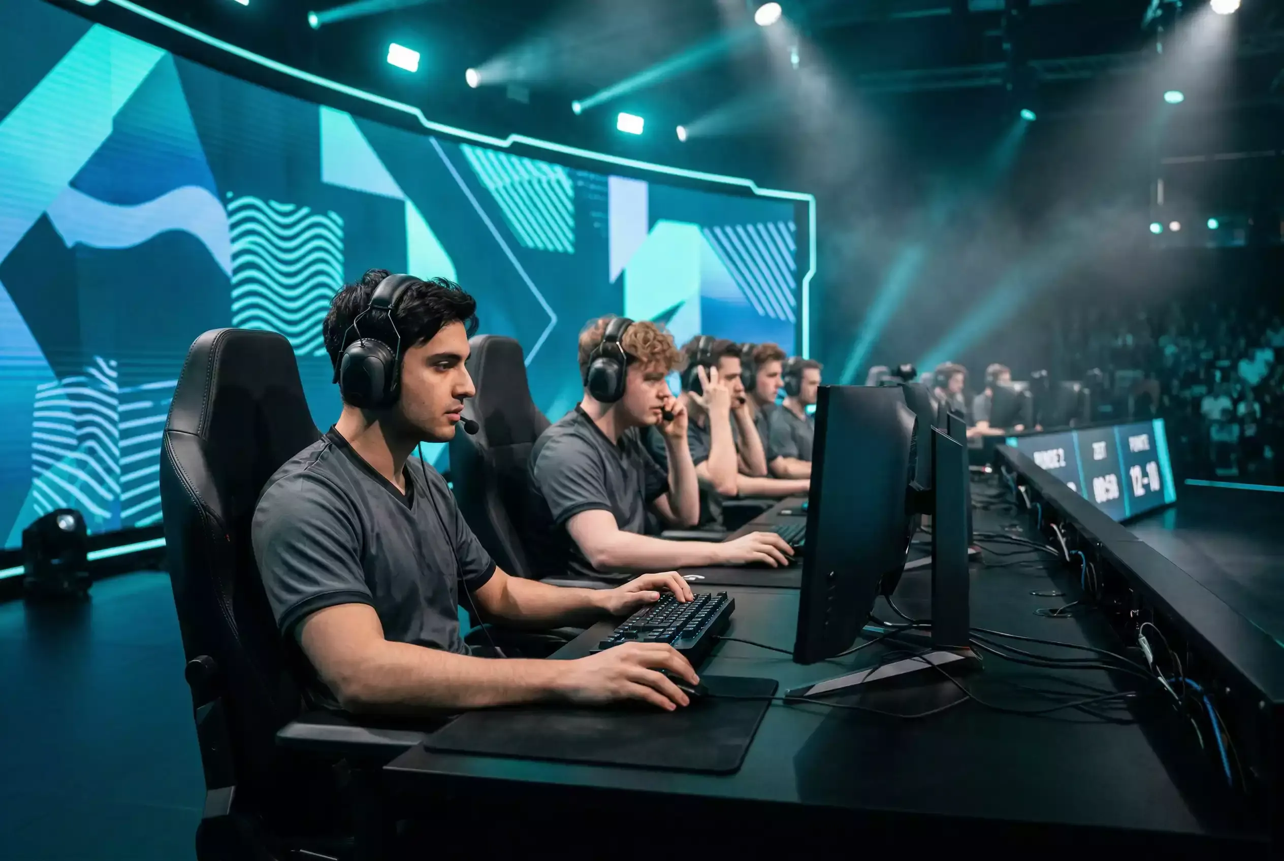 Professionelles eSport-Turnier mit Spielern an Gaming-PCs auf einer Bühne